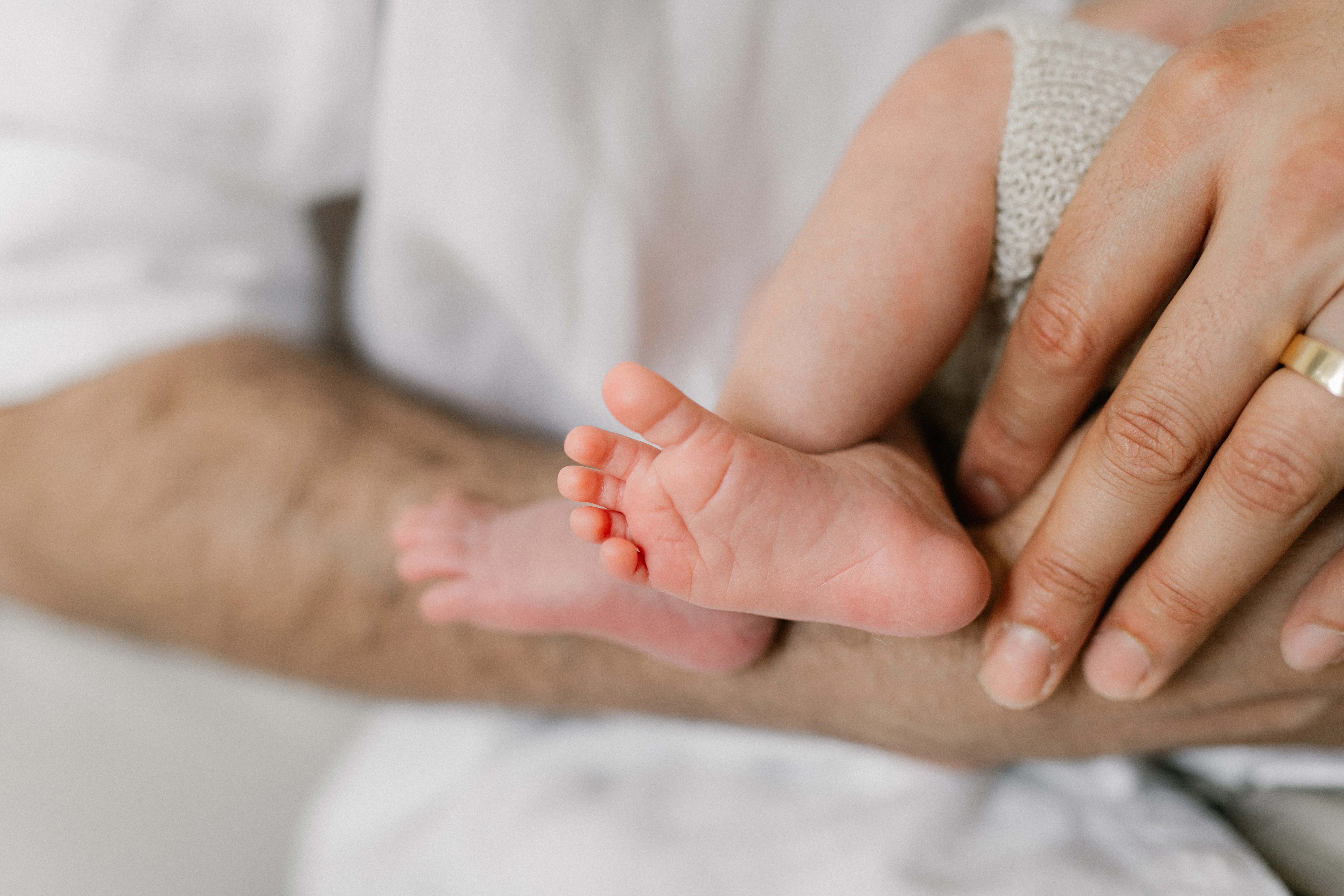 Newborn baby's feet held by a parent's hands